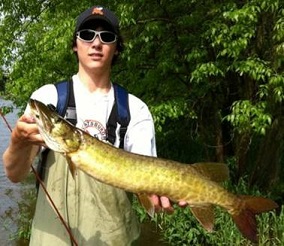 Marshall Maynard carefully hoists a young Great Chazy River muskellunge for a photograph before releasing it to mature and challenge yet another angler